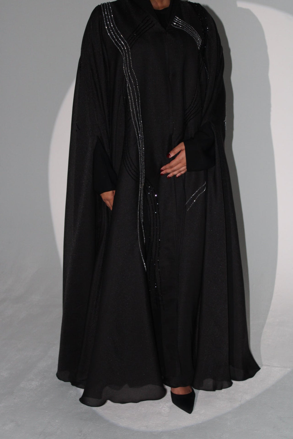 black luxury abaya on a white surface with a gray background