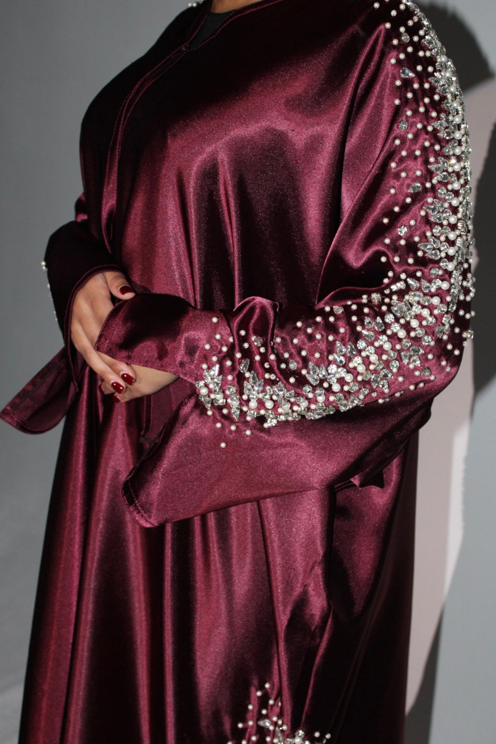 Maroon satin abaya with silver embellishments on sleeves against a neutral background