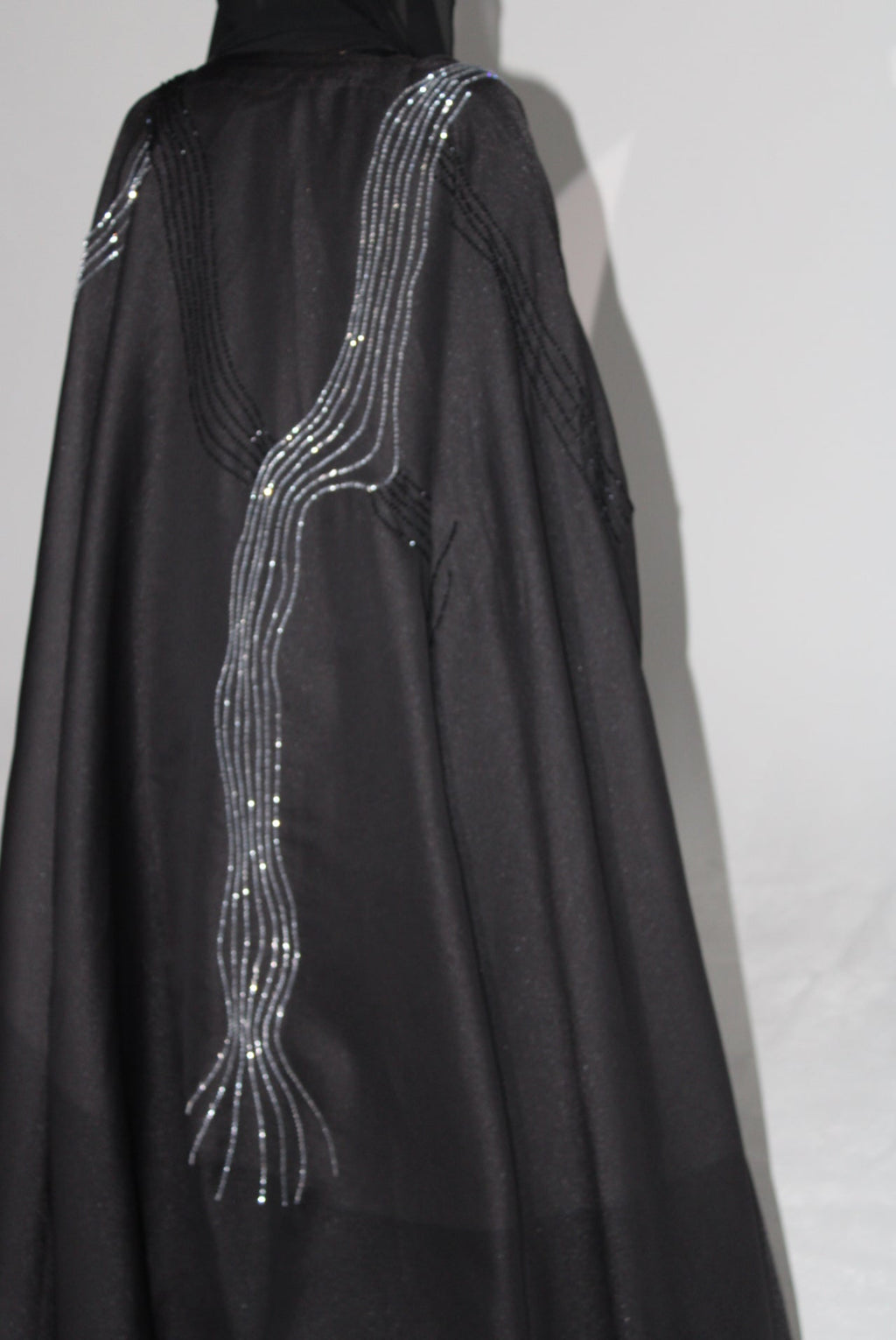 Black luxury abaya with silver thread design on a white background