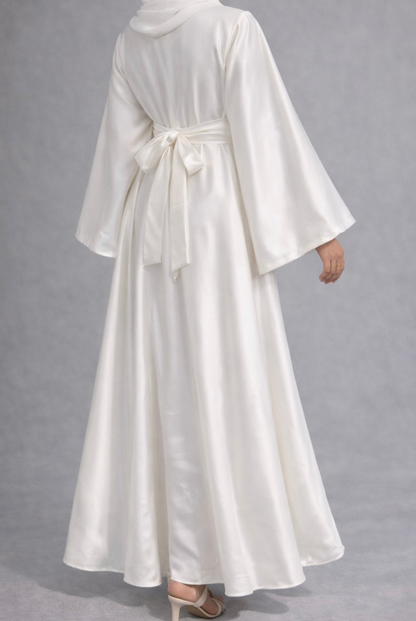 White modest satin dress on a gray background