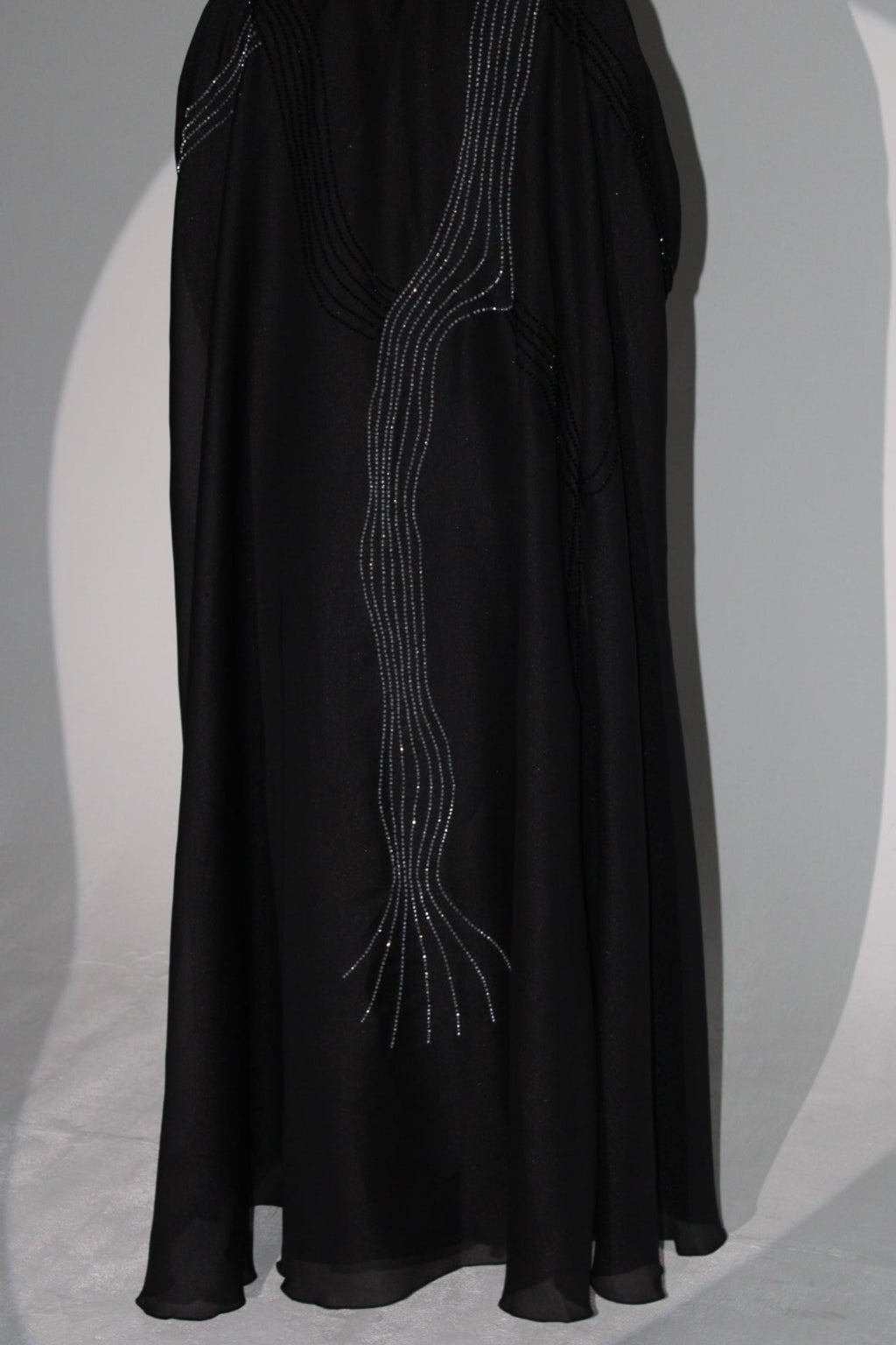 Black luxury abaya with embroidered design on a light gray background