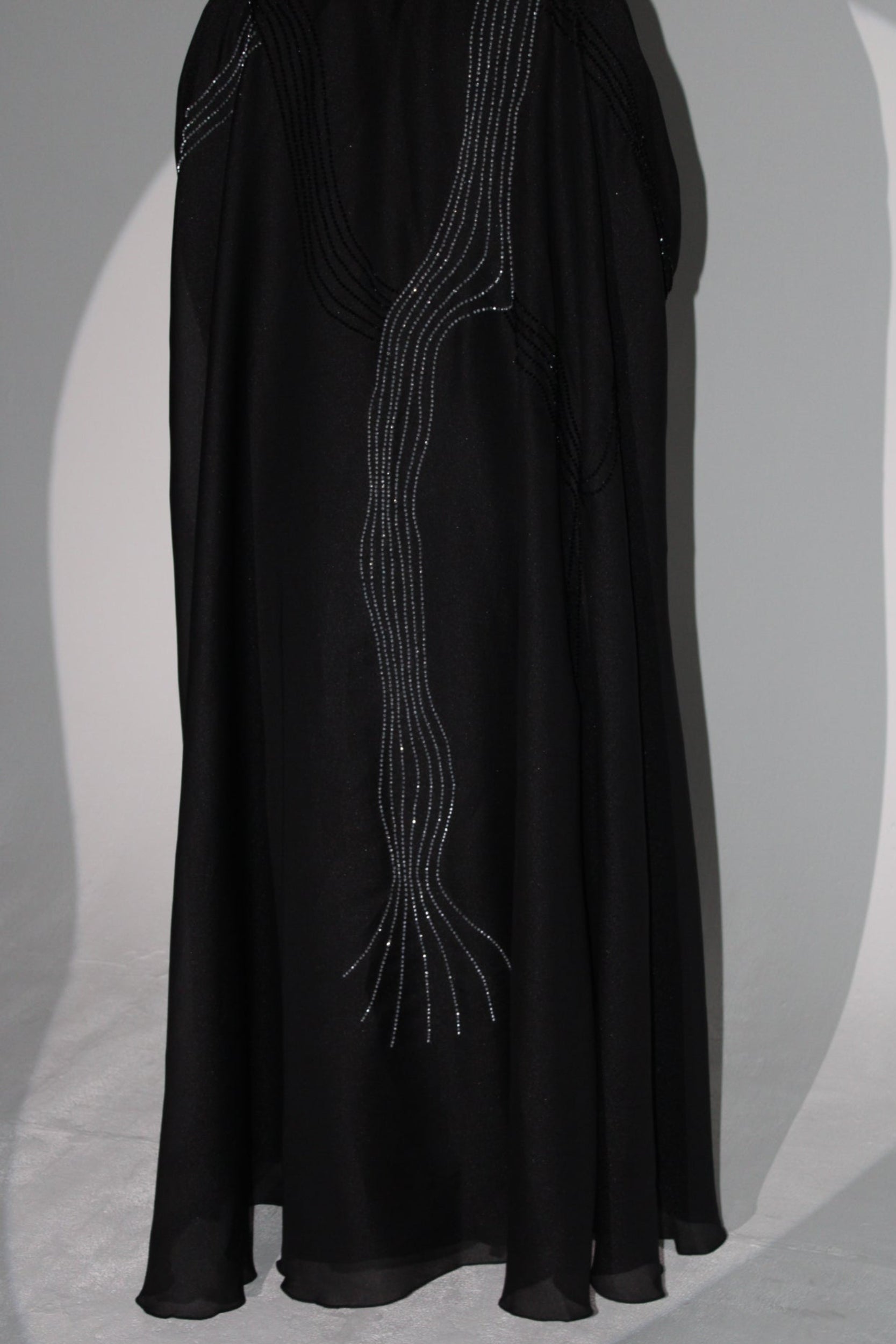 Black luxury abaya with embroidered design on a light gray background