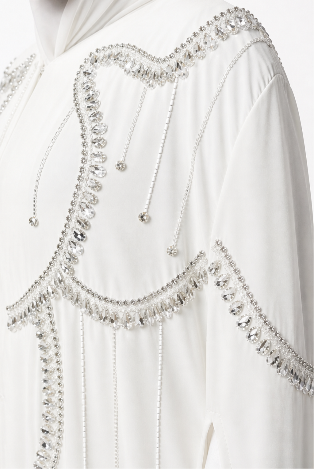 White garment with intricate silver beadwork on a plain background