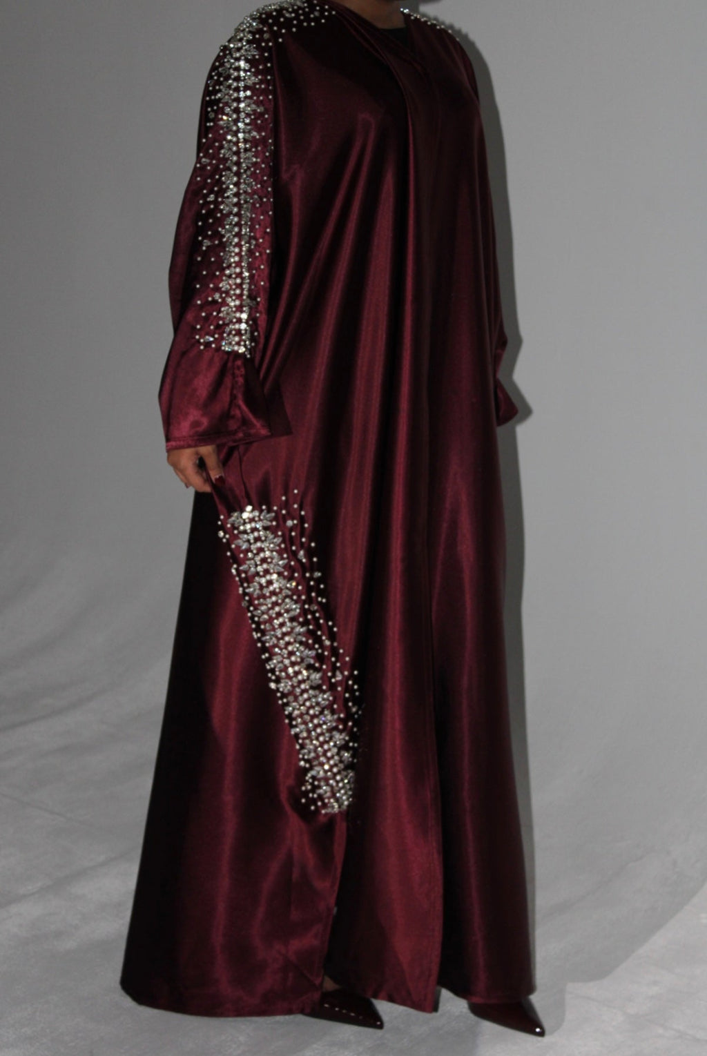 Maroon evening abaya with silver bead embellishments on a gray background