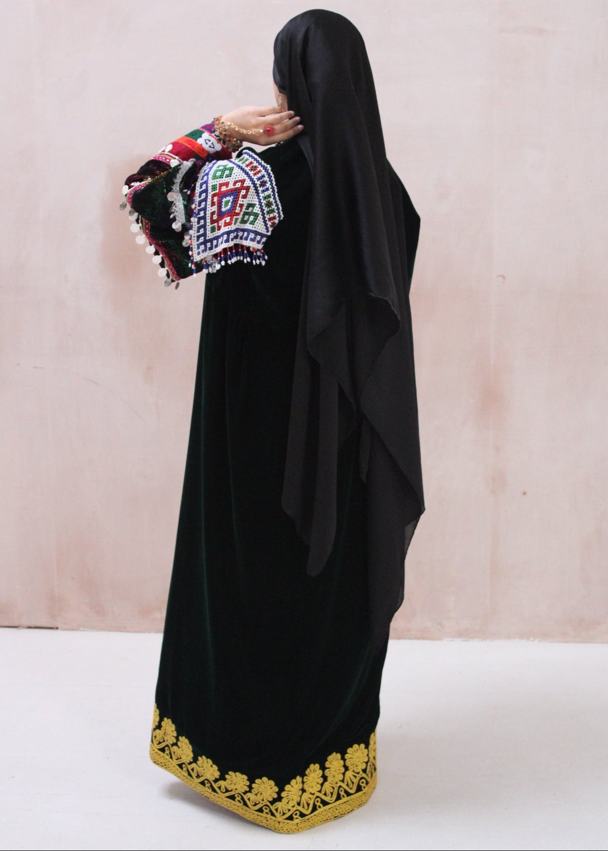 Black traditional outfit with colorful embroidery on a light background