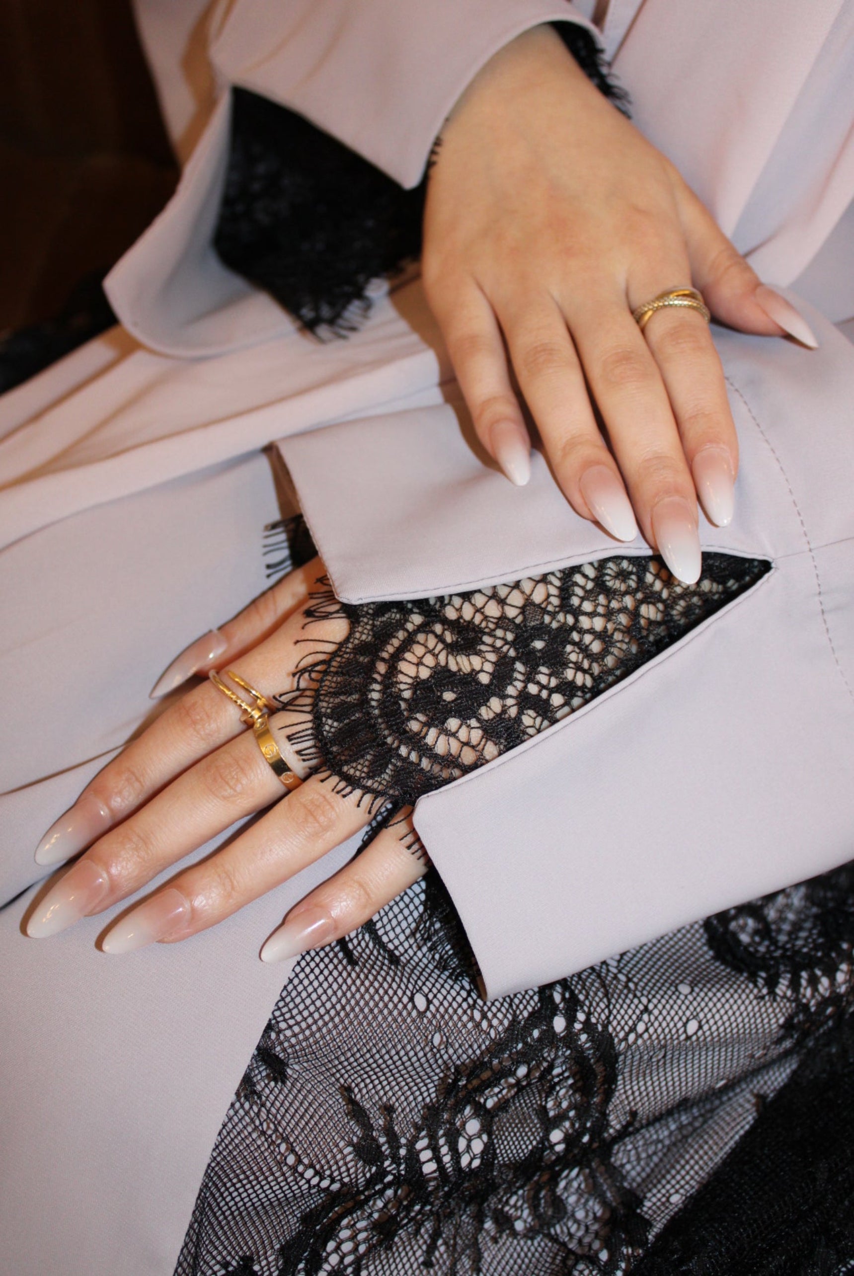 Close-up of a hand wearing a black lace glove with a blurred background