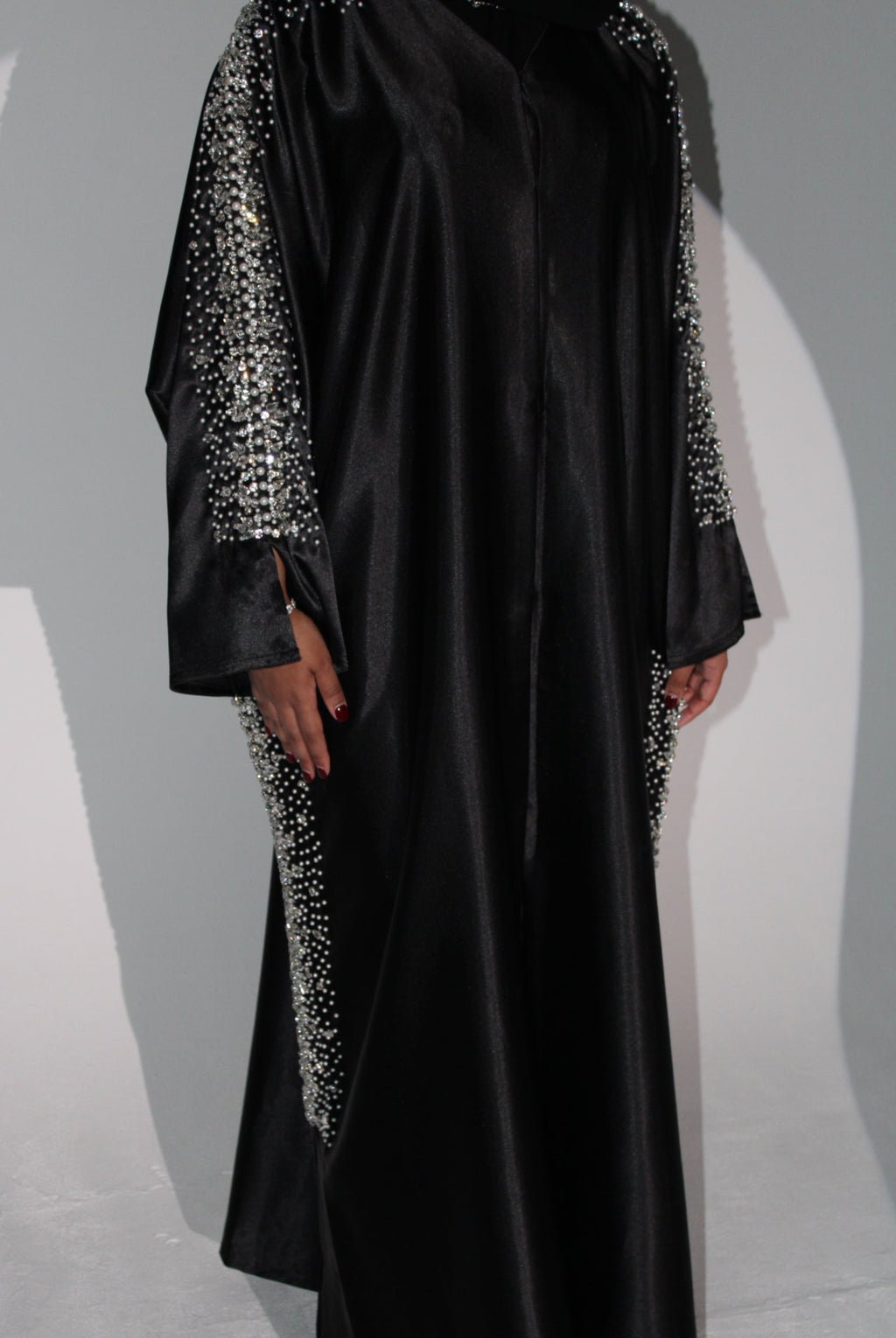 Black evening abaya with sparkling details on a neutral background