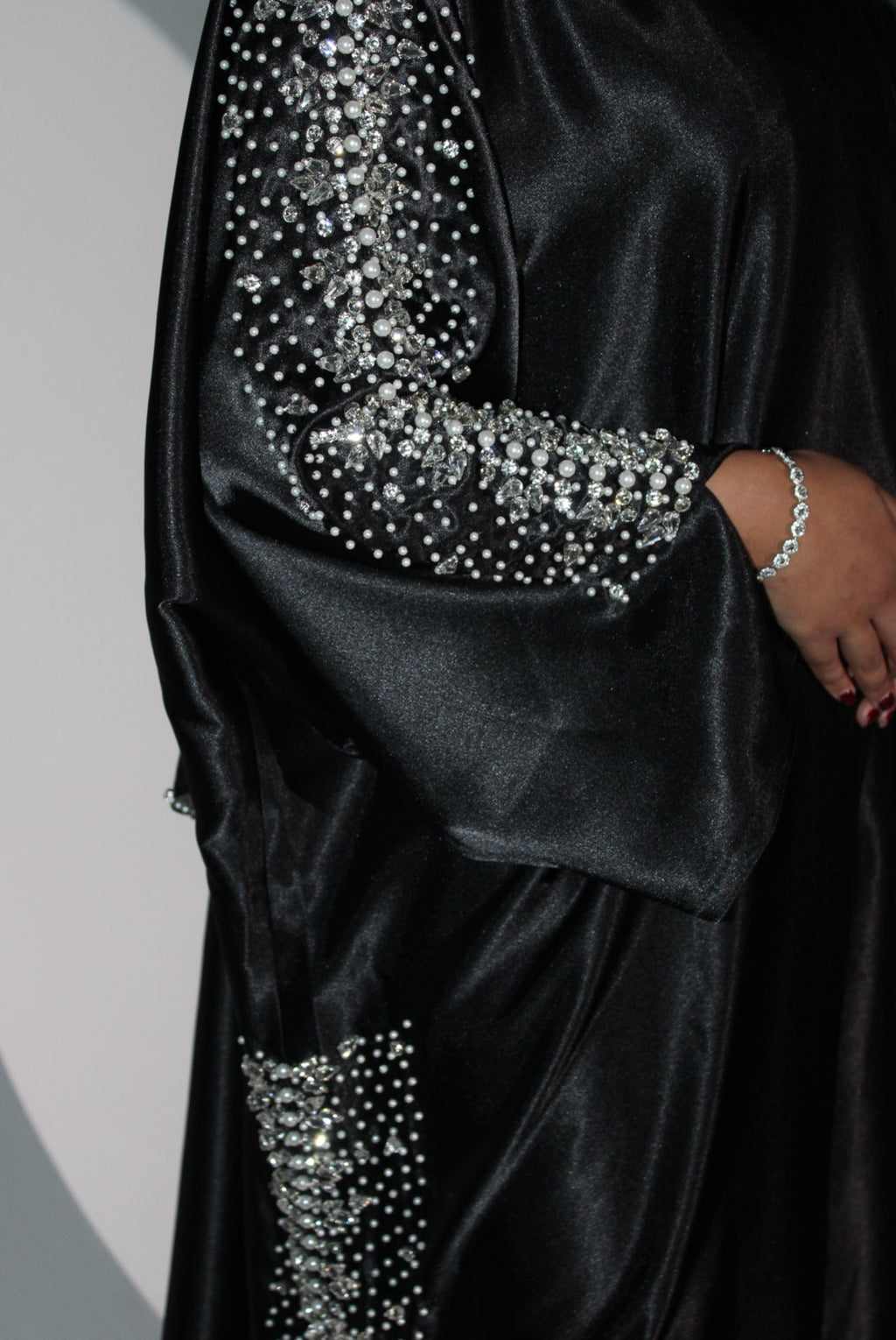 Black abaya with silver embellishments on a neutral background