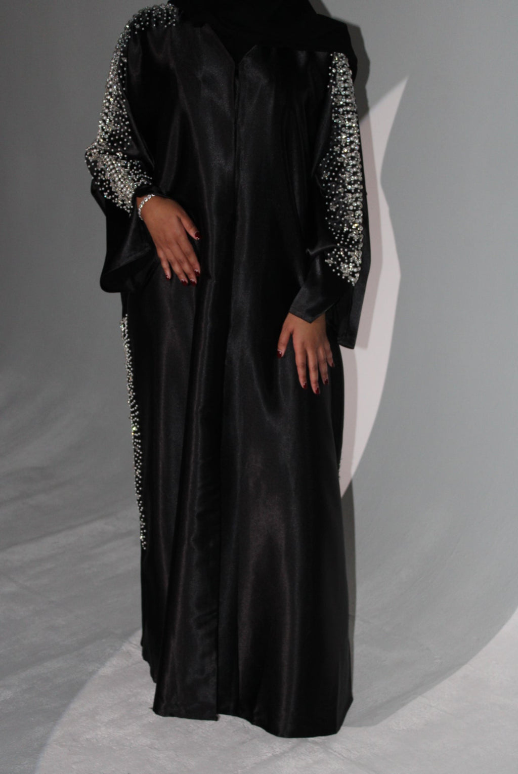 Black evening abaya with embellishments on a gray background