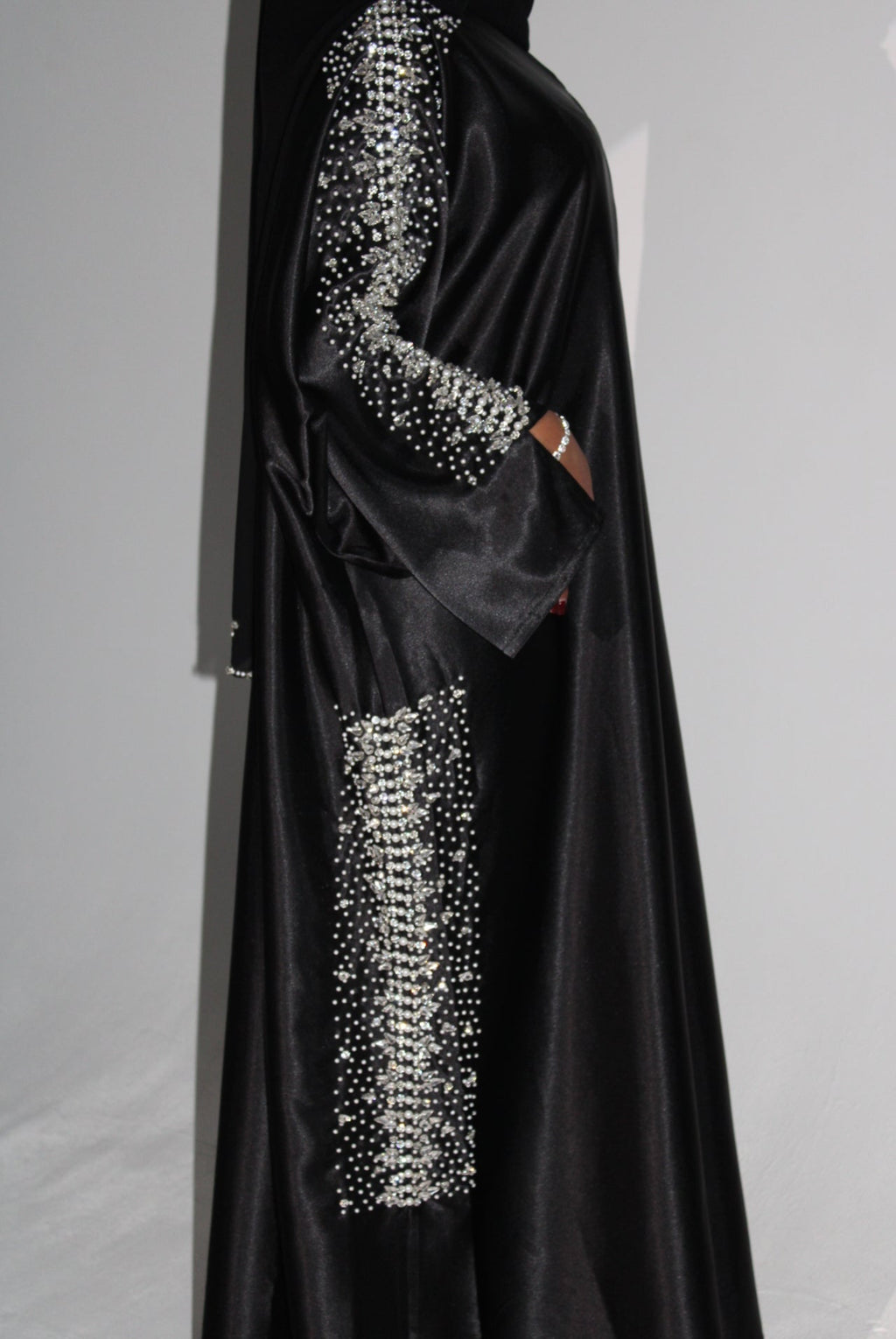 Black evening abaya with silver embellishments on a light gray background