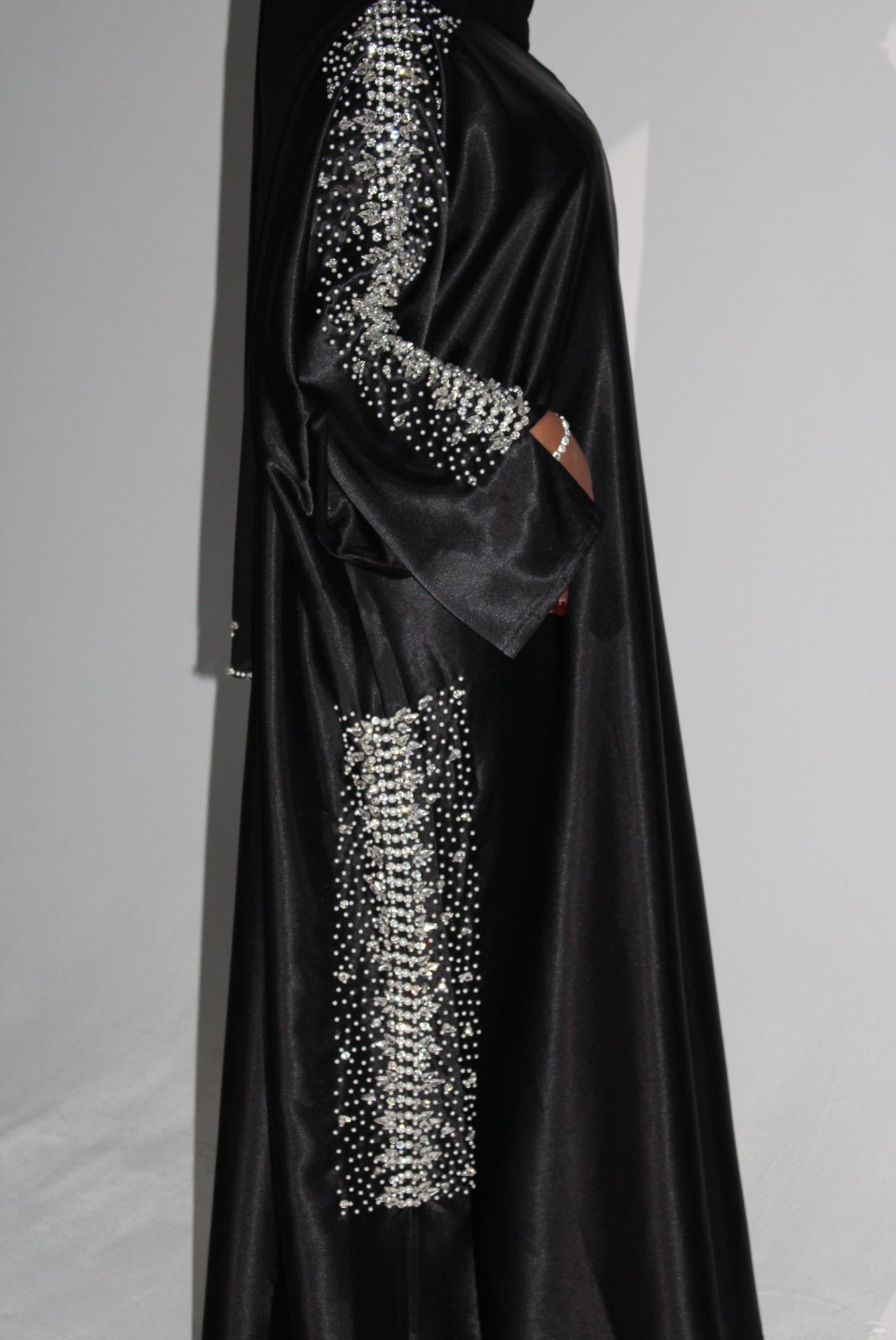 Black evening abaya with silver embellishments on a light gray background