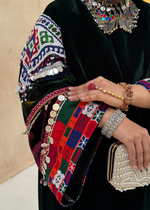 Load image into Gallery viewer, Person wearing a colorful embroidered garment with a beaded clutch and jewelry.
